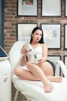 woman in a laser hair removal studio with a cactus in her hand as a symbol of unwanted hair growth