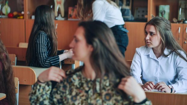 Students in the classroom at their desks in front of the're coming out