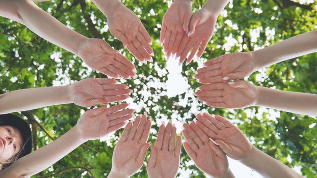 Girlfriends join the palms of their hands in the center making a circle shape