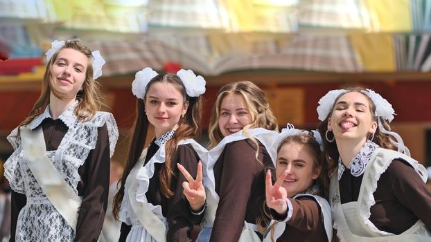 Smiling female graduates pose on the last day of school life