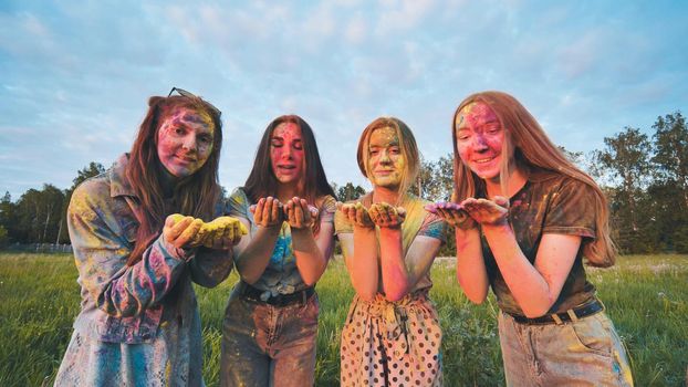 Funny girls are sprinkled with multi-colored powder. Holi holiday