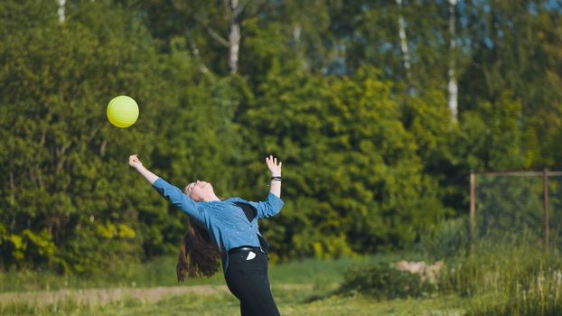 Two girlfriends play volleyball in the meadow