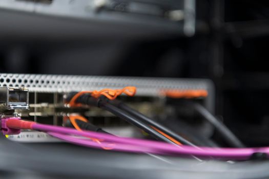 network server room closeup on fiber optic hub or switch for digital communications and internet in mainframe corporate business data center supercomputer. High quality photo