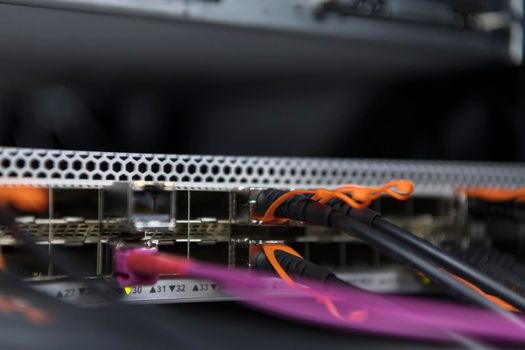 network server room closeup on fiber optic hub or switch for digital communications and internet in mainframe corporate business data center supercomputer. High quality photo