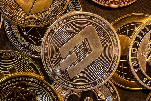 Horizontal view of cryptocurrency tokens, including Dash, Bitcoin, dogecoin, and Ethereum seen from above on a black background. High quality photo