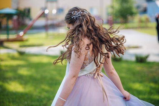 Beautiful schoolgirl in dress at the prom at school