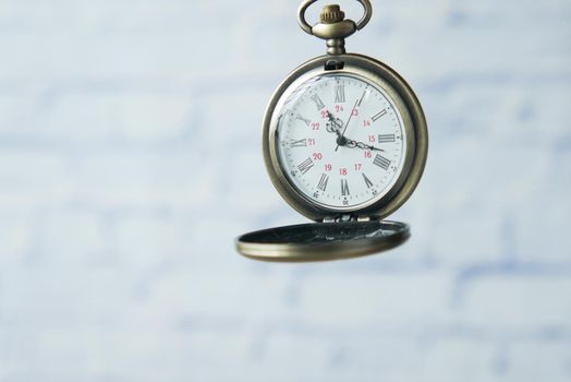 old vintage clock against while wall .