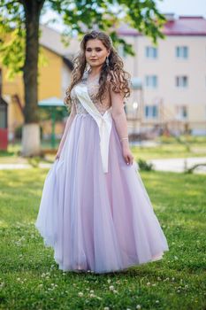 Beautiful schoolgirl in dress at the prom at school