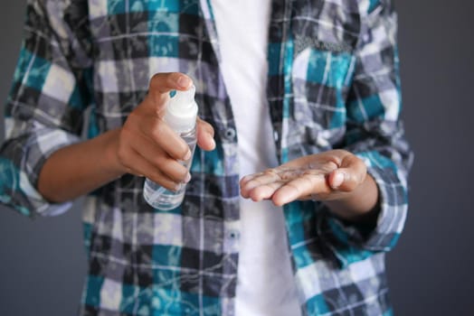 close up of young man hand using hand sanitizer spray