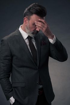 Frustrated middle aged elegant man Close up face of a stressed businessman wearing a stylish suit with eyes closed. Overworked middle eastern business man with terrible migraine. High quality photo