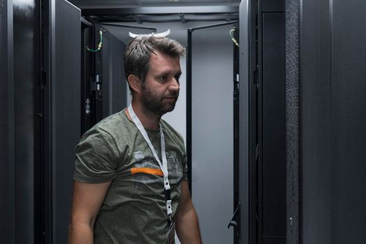 IT engineer working In the server room or data center. The technician puts in a rack a new server of corporate business mainframe supercomputer or cryptocurrency mining farm.