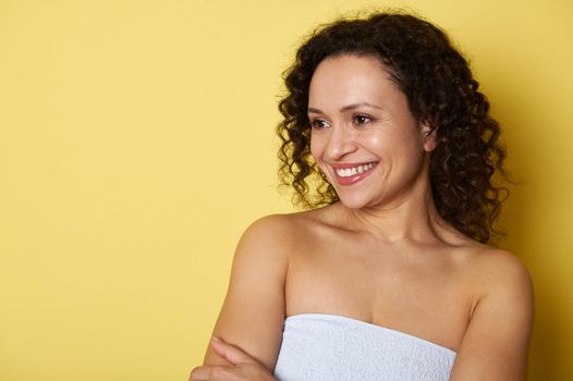 Beauty portrait of a mixed race woman with clean healthy skin on yellow background. Smiling African woman.