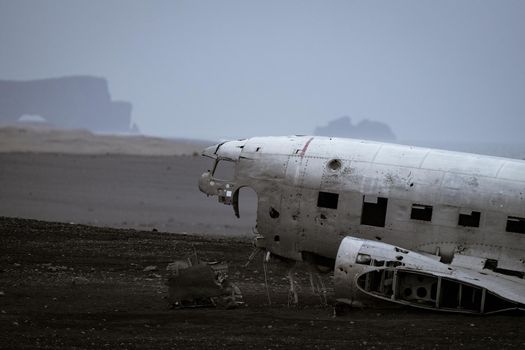 Profile view of abandoned airplane head wreck with huge rocks