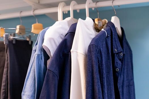 Hangers with different clothes in wardrobe closet