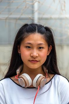 Vertical portrait of Asian teen girl looking at camera. Lifestyle concept.