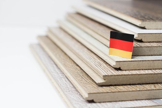 Laminate. Laminated boards. Laying laminate flooring. Floor coverings. German quality. Germany flag on laminate flooring. Quality assurance. Durable floor coverings.