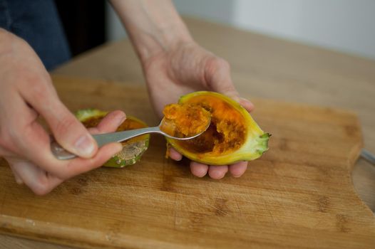 Female eats fresh organic ripe cactus pear or opuntia with a spoon. Exotic fruits, healthy eating concept.