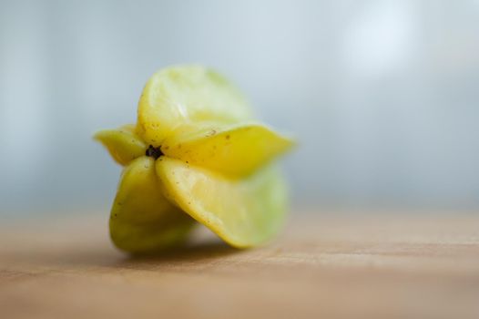 Exotic starfruit or averrhoa carambola on wooden cut board. Healthy food, fresh organic star apple fruit