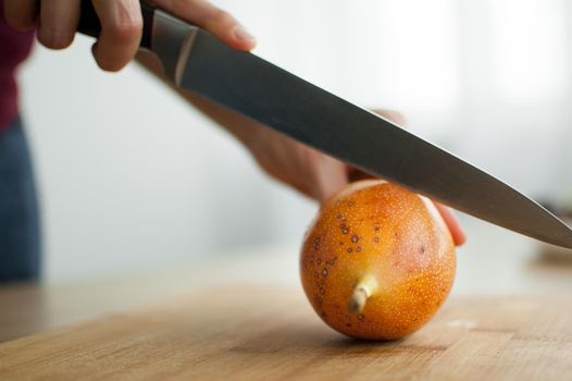 Fresh organic ripe granadilla or yellow passion fruit cut in half on a wooden board. Exotic fruits, healthy eating concept.