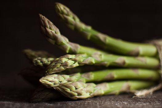 Bunch of fresh green asparagus on dark wooden table, healthy eating, seasonal products.