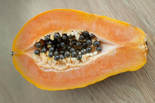 Fresh organic ripe papaya fruit cut in half on a wooden board. Exotic fruits, healthy eating concept.