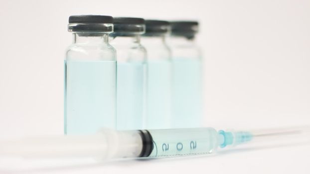 Medical ampoules and insulin syringe isolated on white background, vaccination concept.