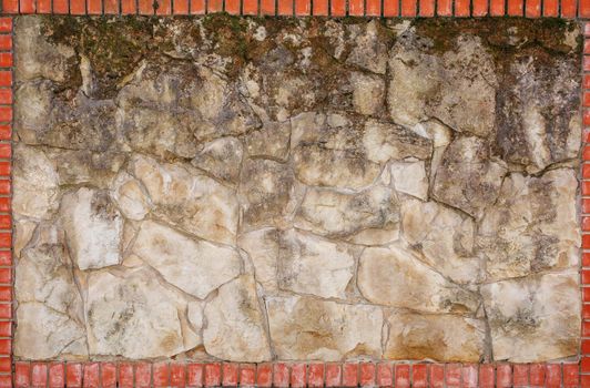 Wall of natural light stone in a red brick frame. Background, texture