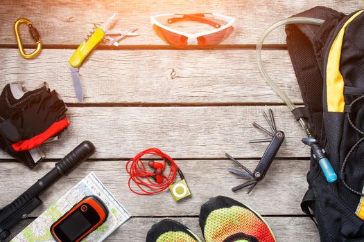 .A set of accessories for cycling on a wooden background, With empty space and a notepad in the middle. Top view set. sunlight