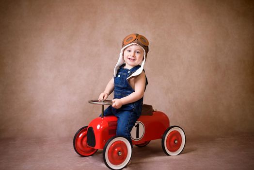 Little boy, playing with wooden cars, indoor, suitcases behind him.