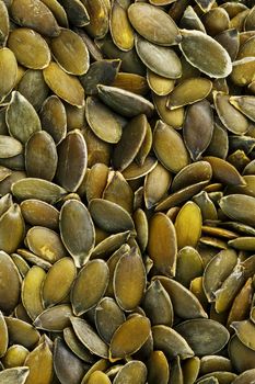 Macro background texture of green pumpkin seeds. Organic vegan food.