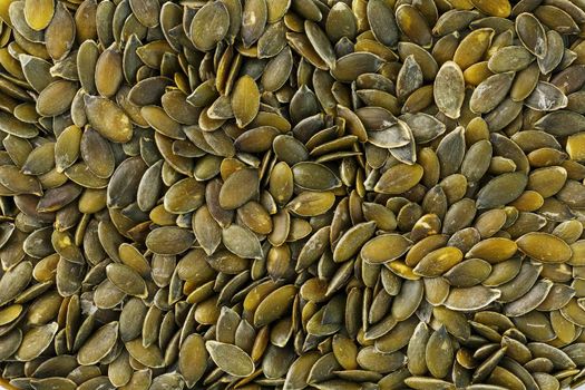 Macro background texture of green pumpkin seeds. Organic vegan food.