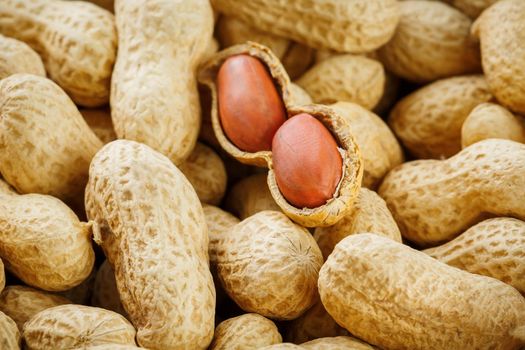Peeled peanut on well peanuts. Uncleaned inshell peanuts. Peanuts, for background or textures.