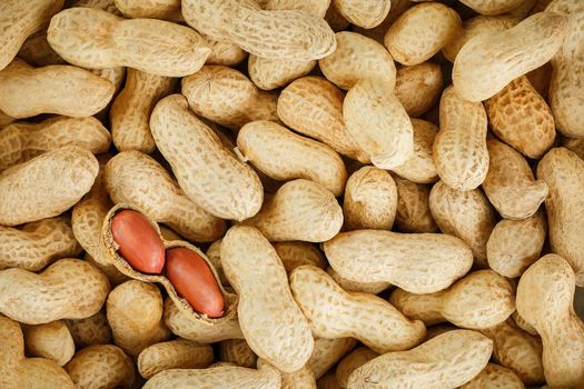 Peeled peanut on well peanuts. Uncleaned inshell peanuts. Peanuts, for background or textures.