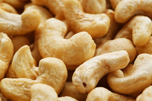 Organic cashew without shell on the background. Organic golden walnut closeup. Macro shot plan.