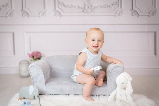 Little girl sitting on sofa with a teddy bear