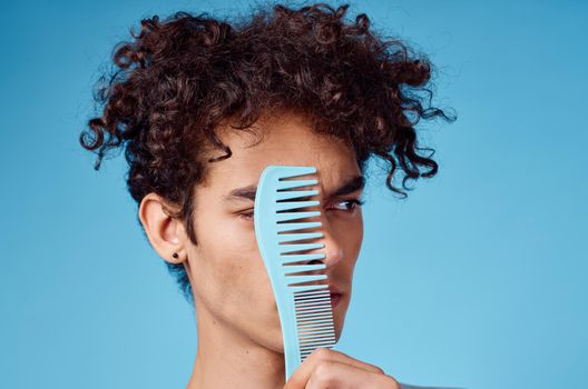 curly guy with a comb hair lifestyle blue background. High quality photo