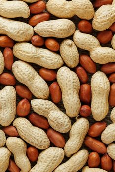 Peanuts in a shell mixed with peeled, the texture of the food background of beans. Organic Vegan Protein Source