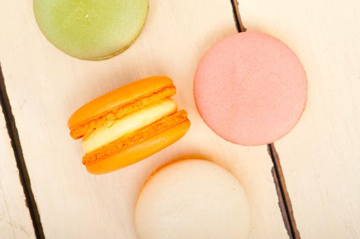 colorful french macaroons over a white rustic wood table 