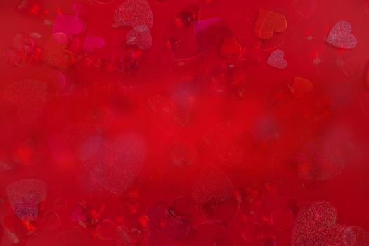 Valentine's Day Heart Abstract Multiple Exposure Background. Predominantly red image with hearts of different sizes, colors, and textures, including shiny, glittery, and gemstone. Lots of copy space.
