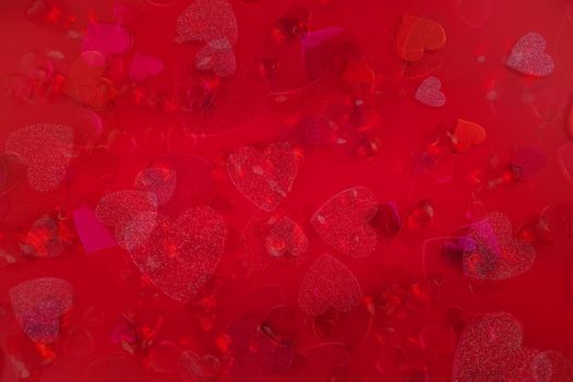 Valentine's Day Heart Abstract Multiple Exposure Background. Predominantly red image with hearts of different sizes, colors, and textures, including shiny, glittery, and gemstone. Lots of copy space.