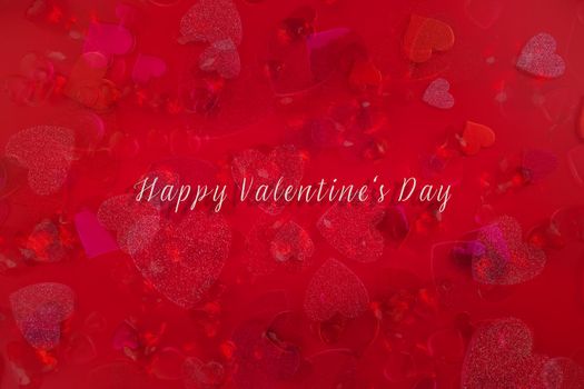 Valentine's Day Heart Abstract Multiple Exposure Background. Predominantly red image with hearts of different sizes, colors, and textures, including shiny, glittery, and gemstone. Lots of copy space. Includes the words, Happy Valentine's Day