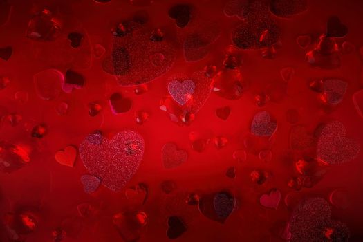 Valentine's Day Heart Abstract Multiple Exposure Background. Predominantly red image with hearts of different sizes, colors, and textures, including shiny, glittery, and gemstone. Lots of copy space.