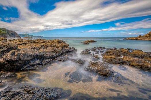 Long exposure, pacific ocean waves on rock in Playa Ocotal, El Coco Costa Rica. Famous snorkel beach. Picturesque paradise tropical landscape. Pura Vida concept, travel to exotic tropical country.