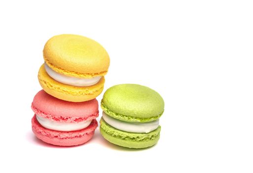 Banner of colorful macaroons isolated on white background. Lemon yellow, strawberry pink and green french cookies. Caramel hazelnut and strawberry cakes in front view. Bakery concept with blank space