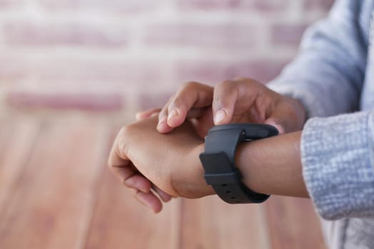 man's hand using smart watch