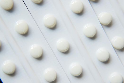 Close up of pills of blister pack on table .
