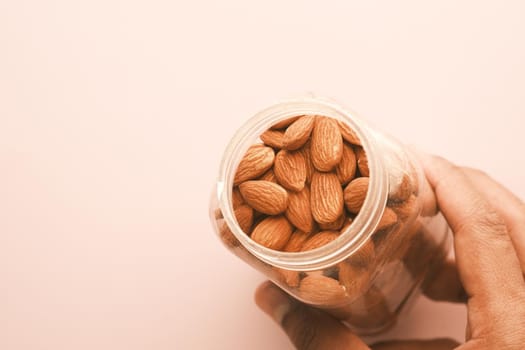 close up of almond nuts on man's hand .
