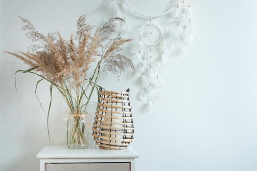 dreamcatcher at scandinavian interior near pampas grass and candlestick. Boho interior decoration design