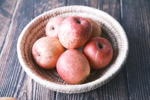 Close up of fresh apple in a bowl on wooden table.