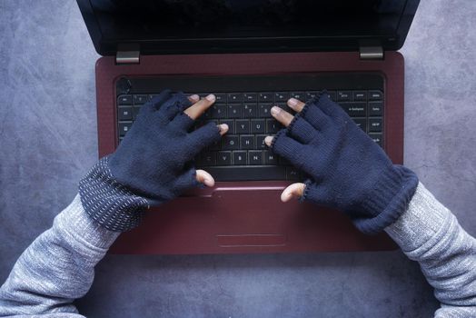 hacker hand stealing data from laptop top down.